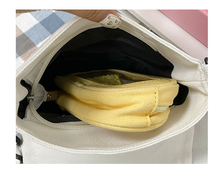 Umhängetasche aus Canvas mit Klappe und Schriftzug